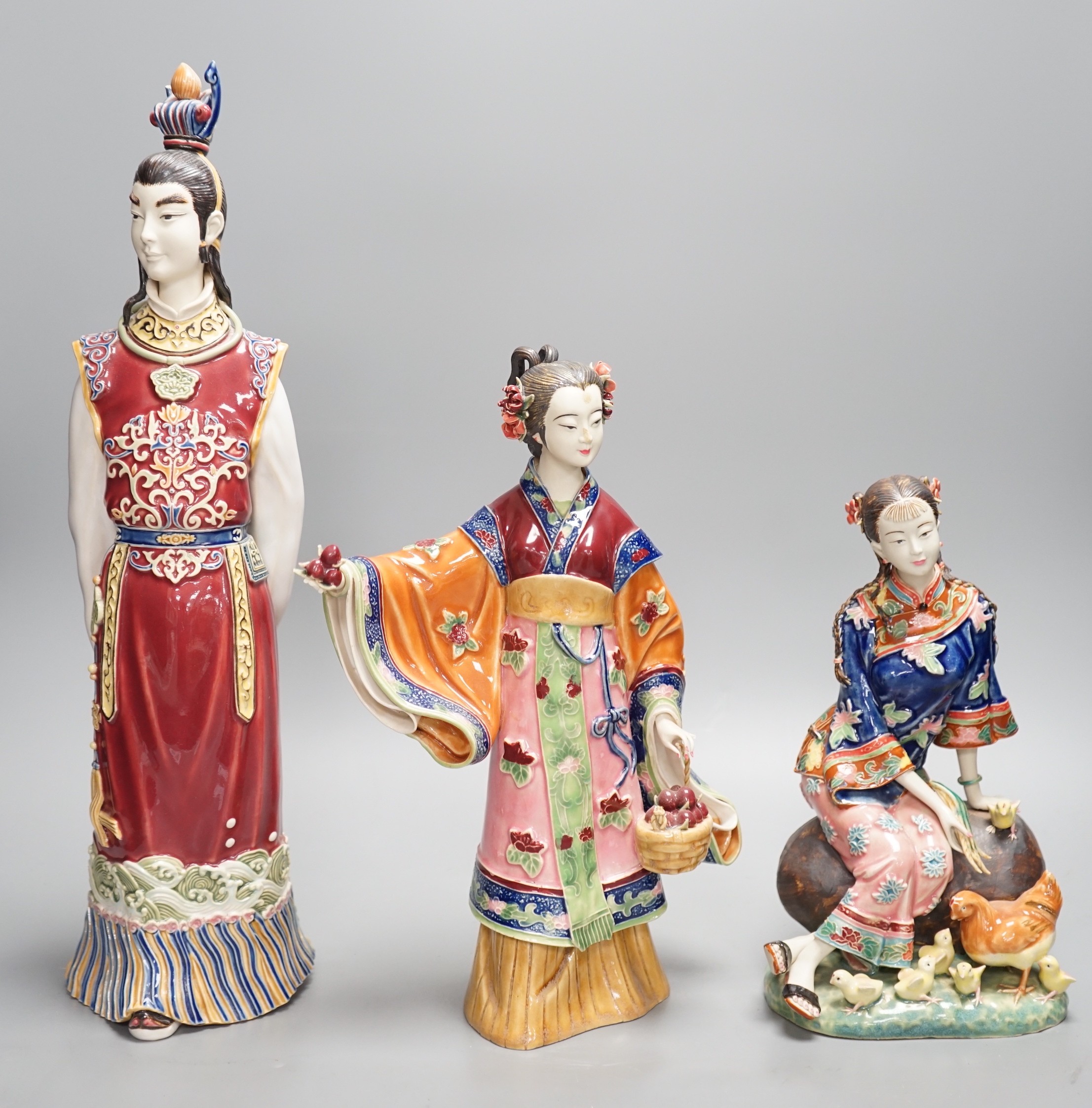 Three Chinese pottery figures, one signed, tallest 42cm